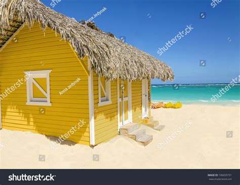 Wooden Yellow Hut On The Beach Covered With Thatch Against Colorful