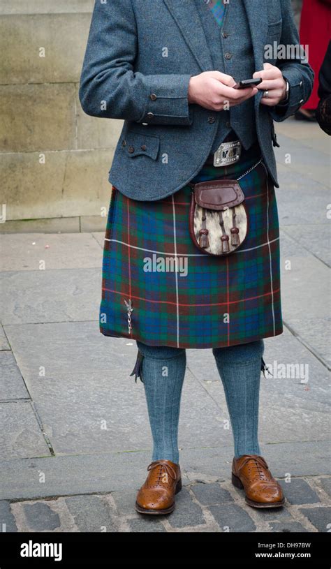 Man Wearing Traditional Scottish Kilt And Sporran Texting On Mobile