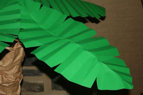 A Paper Palm Tree Made Out Of Brown Paper And Some Green Leaves On Top Of It