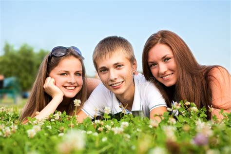 Trois Jeunes Adolescents Heureux Photo Stock Image Du Groupe Herbe