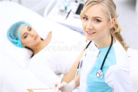 Female Doctor And Young Woman Patient In Hospital Physicians Examine Girl Lying At The Bed