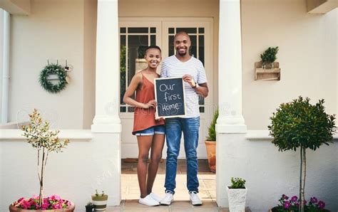 We Bought Our First House Portrait Of A Young Couple Holding A Chalkboard With Our First Home