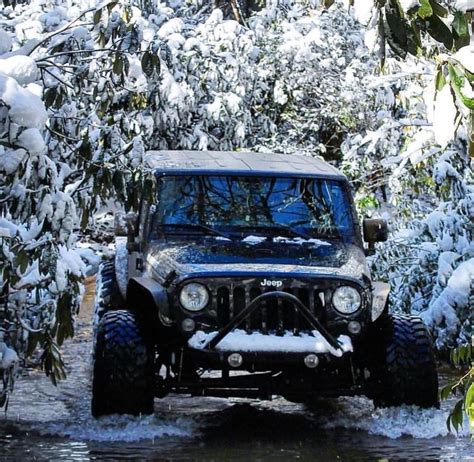 A Jeep Is Driving Through Some Water In The Woods Covered With Snow And