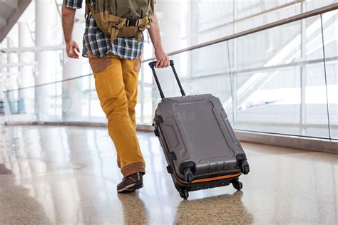 Man Pulling Luggage In An Airport Stock Photo Pixeltote