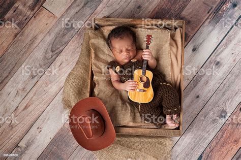 Newborn Baby Cowboy Playing A Tiny Guitar Stock Photo Download Image