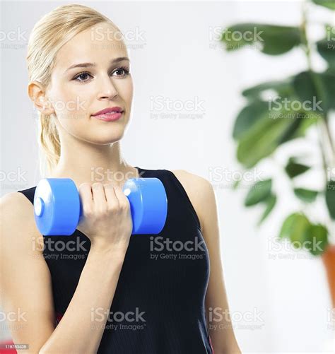 Woman In Sportswear Doing Fitness Exercise With Dumbbell Indoors Stock