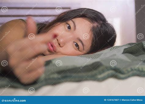 Young Beautiful And Happy Asian Chinese Woman Lying In Bed At Home Bedroom Smiling Cheerful And