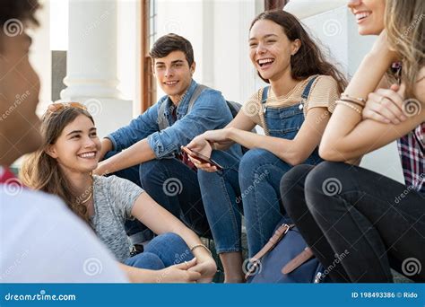 Amigos Adolescentes Sentados Juntos Y Riendo Foto De Archivo Imagen