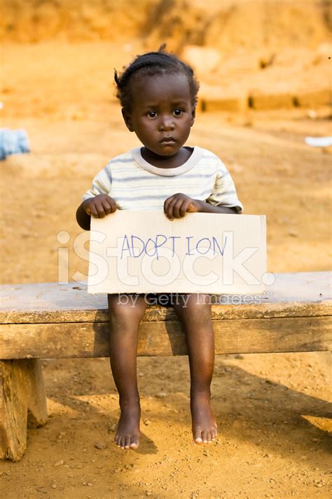 African Girl Holding A Sign With Adoption Written On It Stock Photo