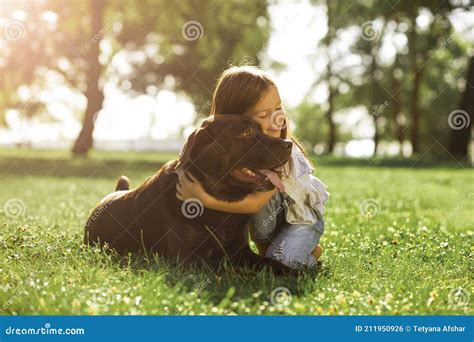 Cute Girl Hugging Her Dog In The Park At Daytime Stock Photo Image Of