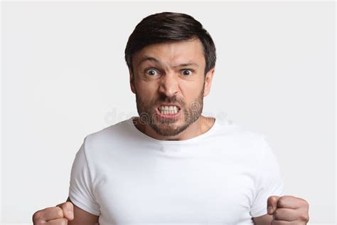 Furious Man Clenching Fists In Rage On White Studio Background Stock