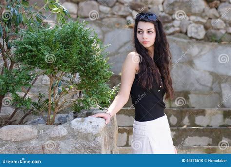 Brunette Curly Hair Lady Standing In Profile On Pebbles Steps Stock