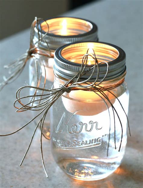 Two Mason Jars Filled With Candles Sitting On Top Of A Countertop Next