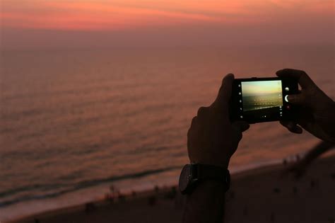 Unrecognizable Man Photographing Ocean During Sundown · Free Stock Photo