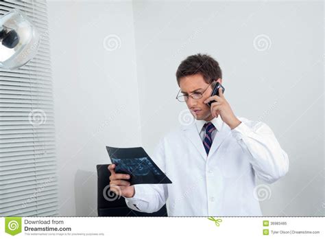 How to xray photos on phone. Male Dentist With X-Ray Using Mobile Phone Stock Image ...