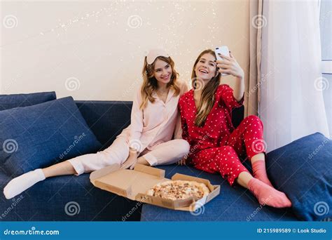 Lovable Curly Young Woman In White Socks Smiling While Her Friend Making Selfie At Home Indoor