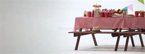 Picnic Table And Red Checkered Tablecloth With Food And Drink For
