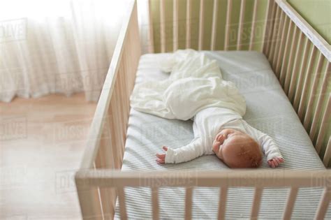 High Angle View Of Baby Boy Sleeping In Crib At Home Stock Photo