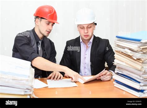 Architect And Construction Engineer Discussing Plan In Office Room