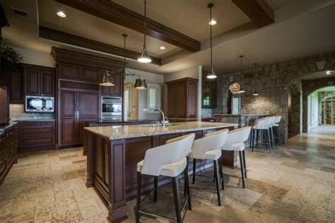 A Large Kitchen With Marble Counter Tops And Bar Stools