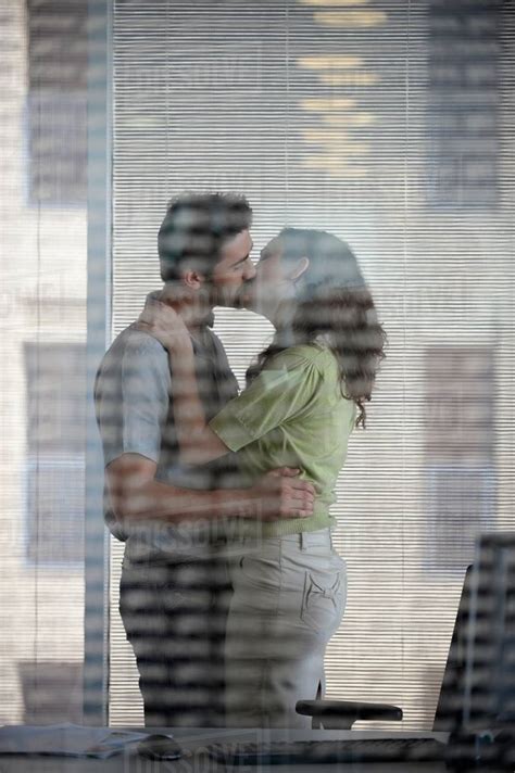 Couple Kissing In Office Stock Photo Dissolve