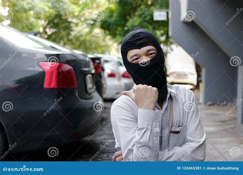 Masked Burglar Wearing A Balaclava Ready To Burglary Against Car Background Insurance Crime
