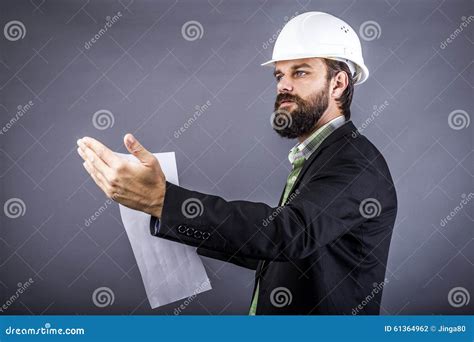 Portrait Of Young Engineer Holding Plan Drawings And Explaining Stock