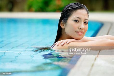 Chinese Woman Leaning In Edge Of Swimming Pool Photos And Premium High
