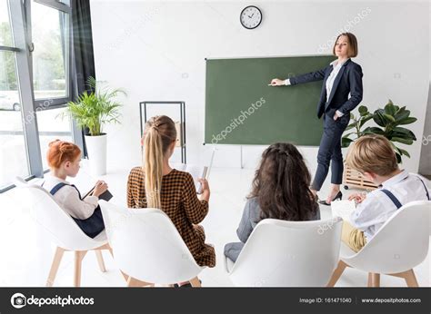 Teacher Explaining Lesson To Students Stock Photo By ©edzbarzhyvetsky
