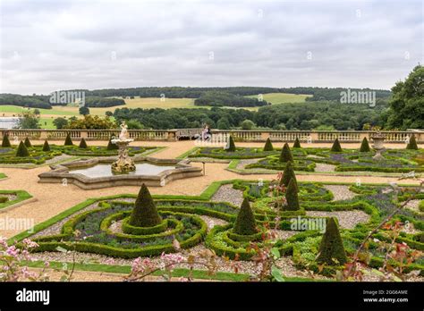Parterre gardens with triton fountain and topiary shrubs. Rural scene