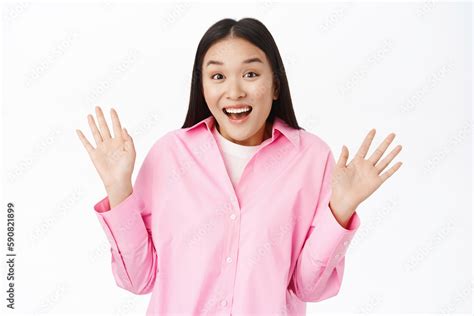 Enthusiastic Asian Girl Looks Surprised Raise Palms Shows Empty Hands With Happy Face Stands