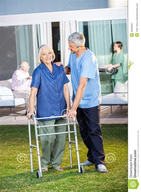 Senior Woman Being Assisted By Male Caretaker Stock Image Image Of