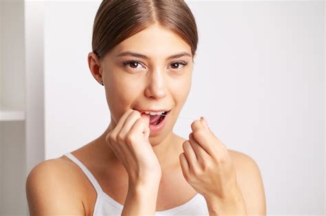 Premium Photo Cheerful Brunette Woman Using Dental Floss In Bathroom