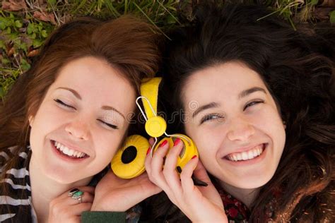 Happy Teen Girls Sharing Music Stock Photo Image Of Female Lying