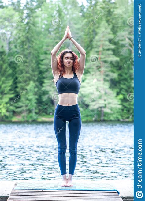 Young Yogi Girl Practicing Yoga Hasta Uttanasana On The Lake Concept