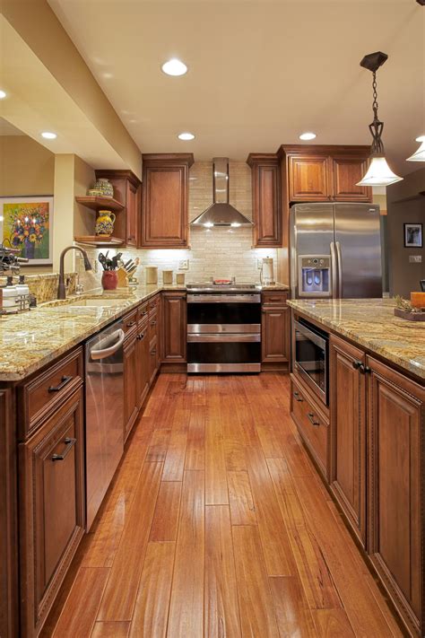 We created a sophisticated and functional kitchen using cherry cabinetry in a chocolate glazed finish, and gorgeous taj mahal granite that has the appearance of. Woods in warm, rich medium brown tones were used to great ...