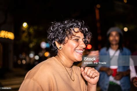 Mid Adult Woman Partying With Friends In The Street At Night Stock