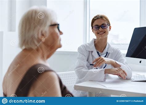 Ältere Frau Mit Brille Mit Der Assistentin Des Pflegearztes Spricht Stockbild Bild von