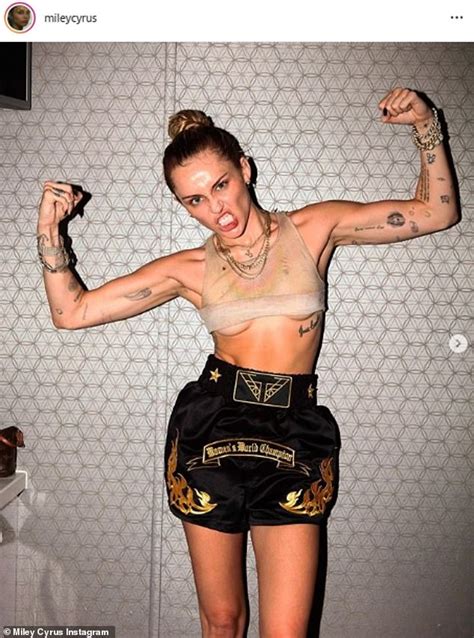 miley cyrus flashes underboob and impressive abs as she flexes her arms while celebrating her