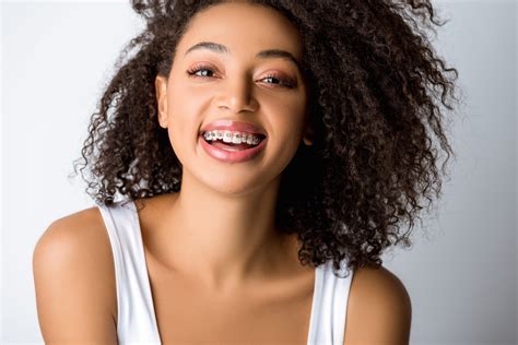 laughing african american girl with dental braces isolated on g sussex dental group sussex