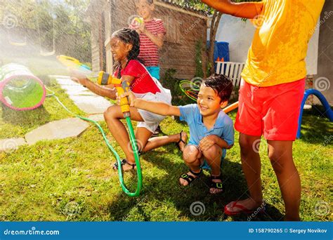 Group Of Kids Play Water Gun Fight Game Outside Stock Image Image Of