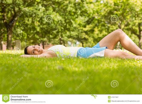 Happy Fit Brunette Lying And Relaxing On The Grass Stock Image Image