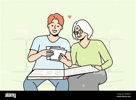 Elderly Woman And Her Son Are Looking At Old Photos In Photobook
