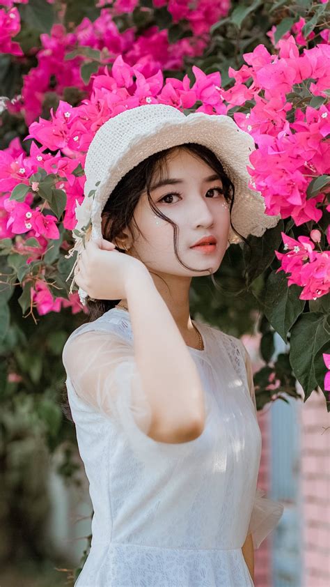 Download Asian Women Posing By The Flowers Wallpaper