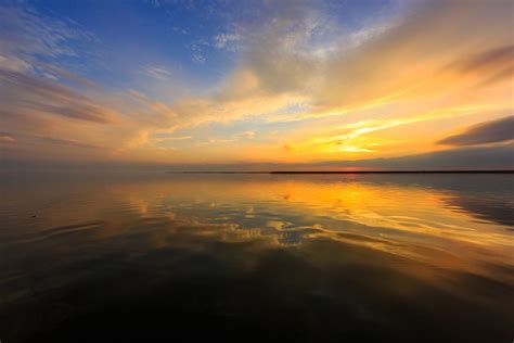 Golden Hour Photograph Lights The Sky Over The Calm Bay Water Of Little
