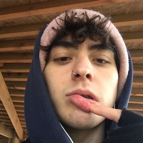 A Young Man Wearing A Hoodie With His Finger In His Mouth