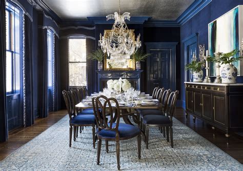 An Elegant Dining Room With Blue Walls And Chandelier