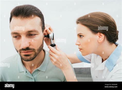 Ent Doctor Checking Adult Male Ear Using An Otoscope Hearing Exam For