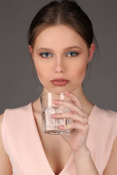 Girl With Makeup Holding Glass Of Water Close Up Gray Background