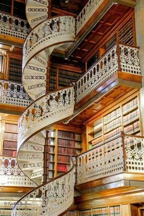 A Spiral Staircase In A Library With Bookshelves